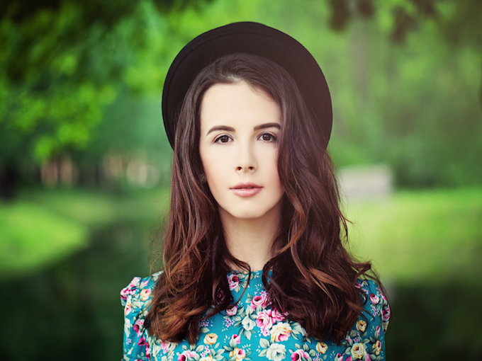 Fashion Model Girl on Green Background Outdoors